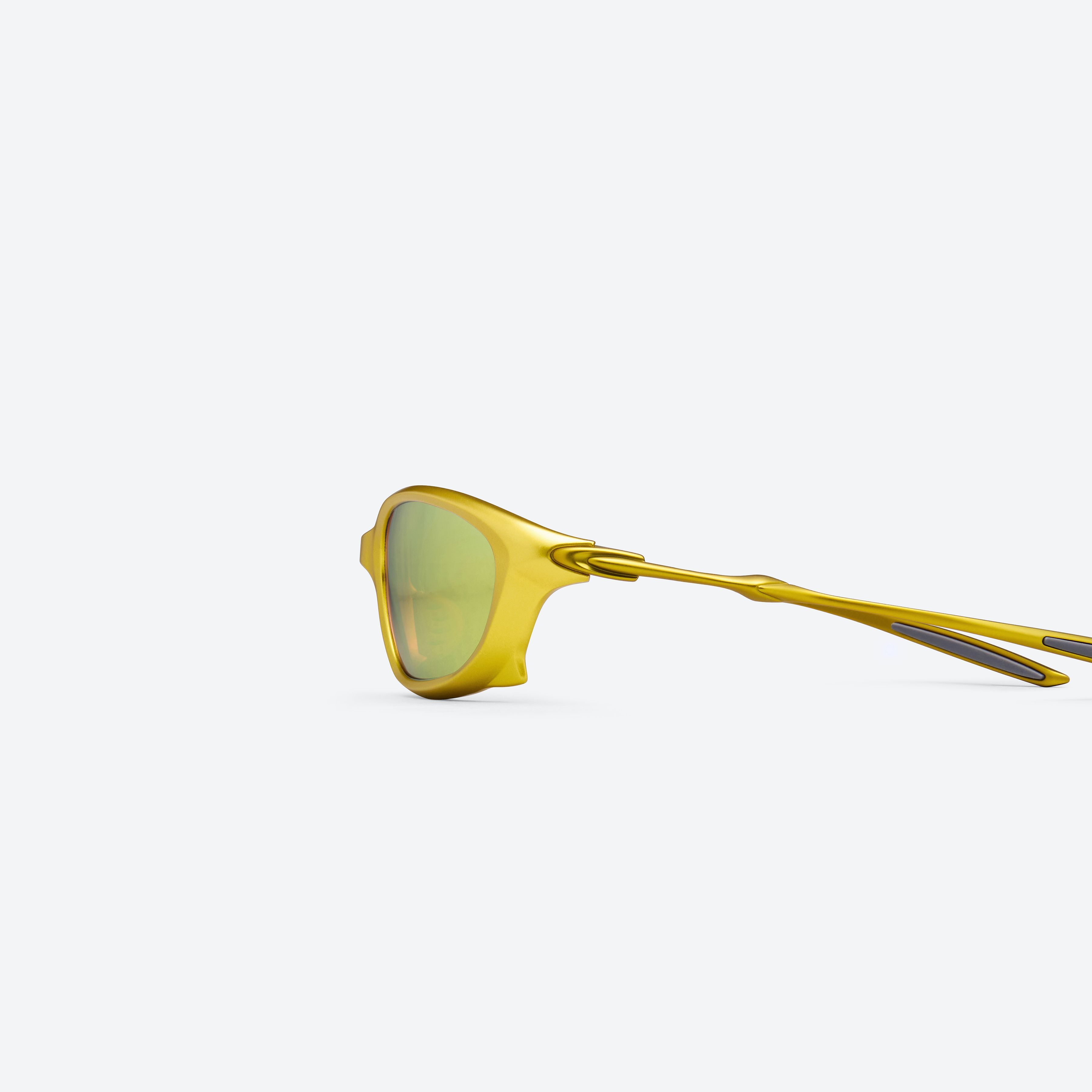 A detailed left view of Gentle Monster Turbo MGD3 Gold Mixed framed Wraparound sunglasses.