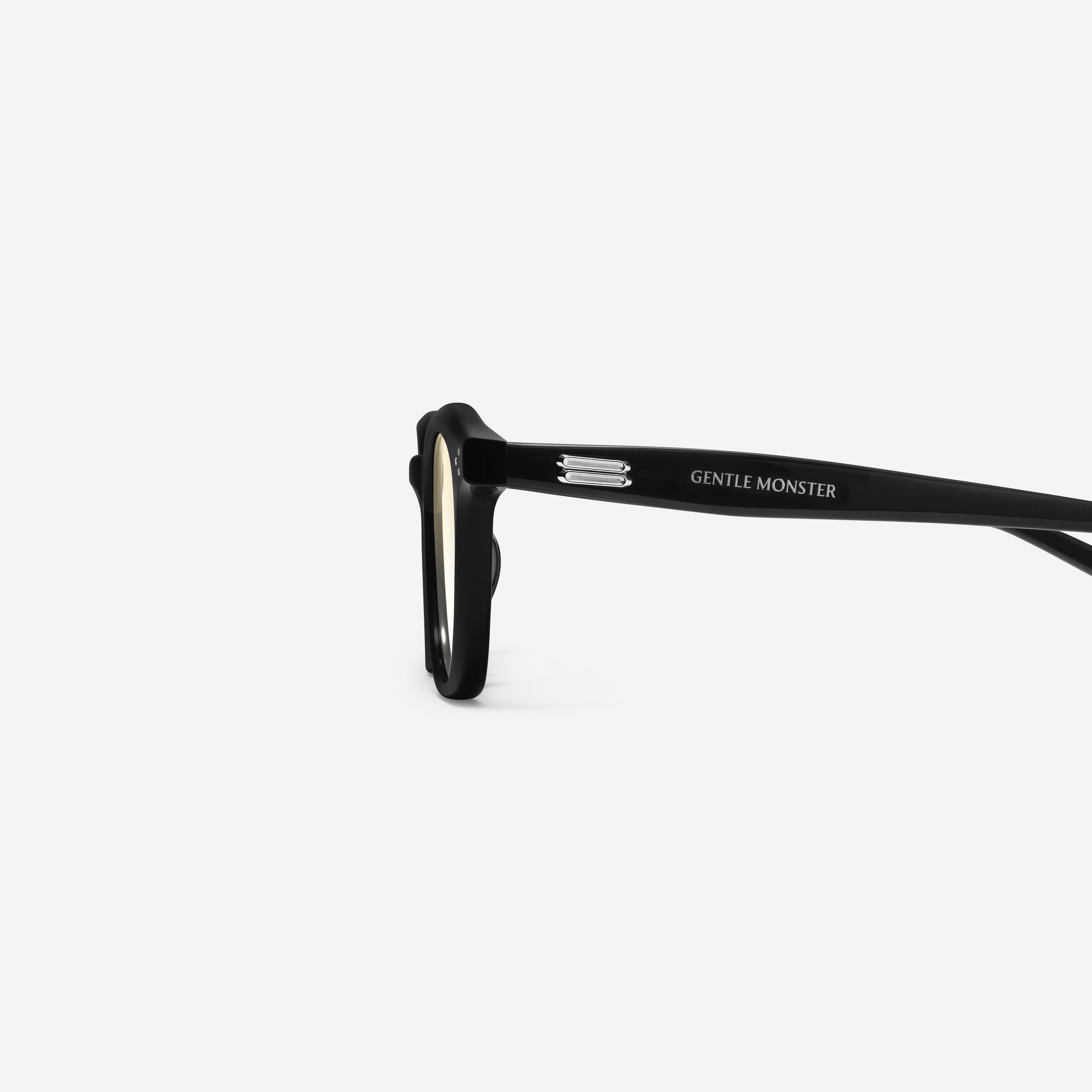 A detailed left view of Gentle Monster Noho 01(BYG) Black Acetate framed Round sunglasses.