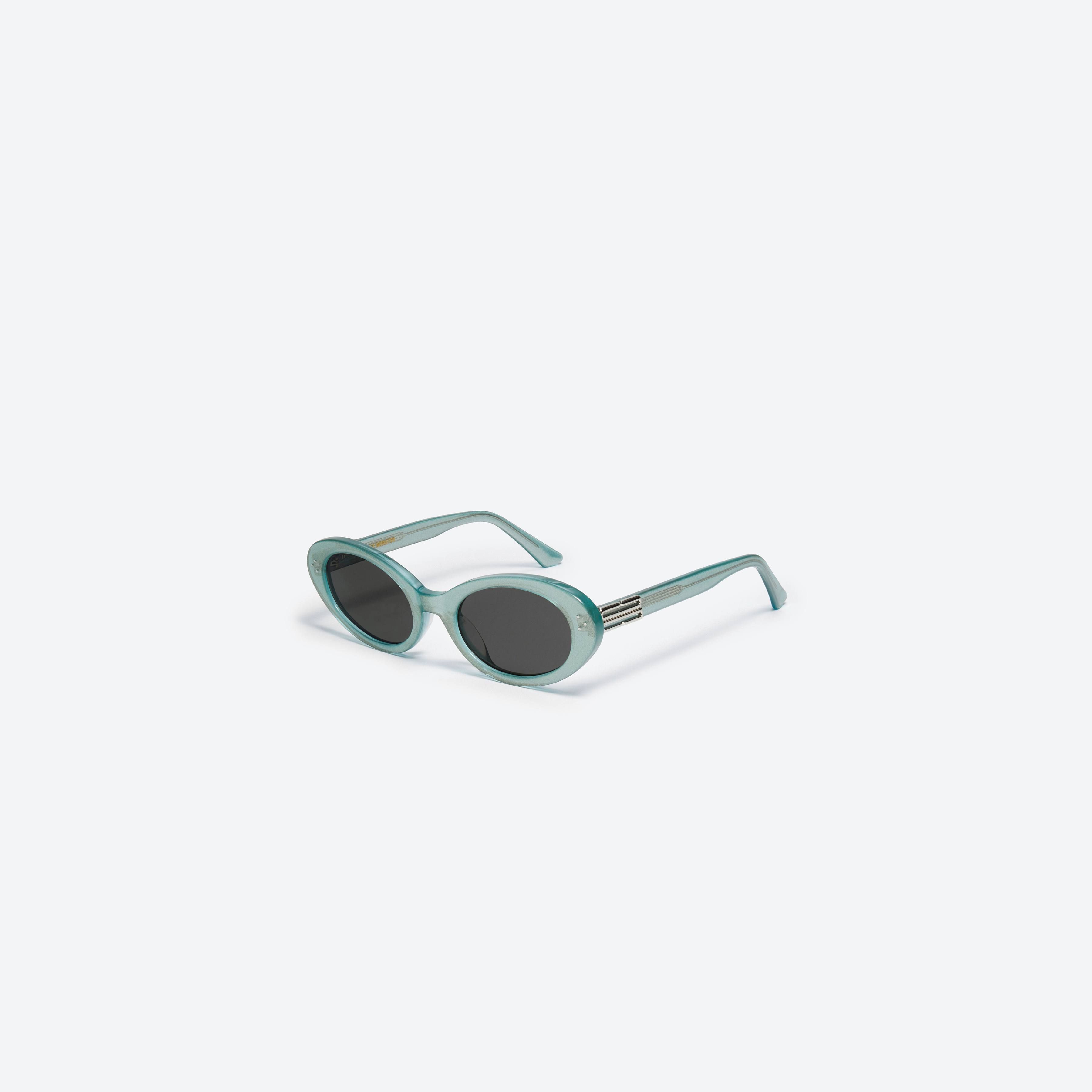 45-degree view of Gentle Monster Jeans GRC4 Green Acetate framed Oval sunglasses.