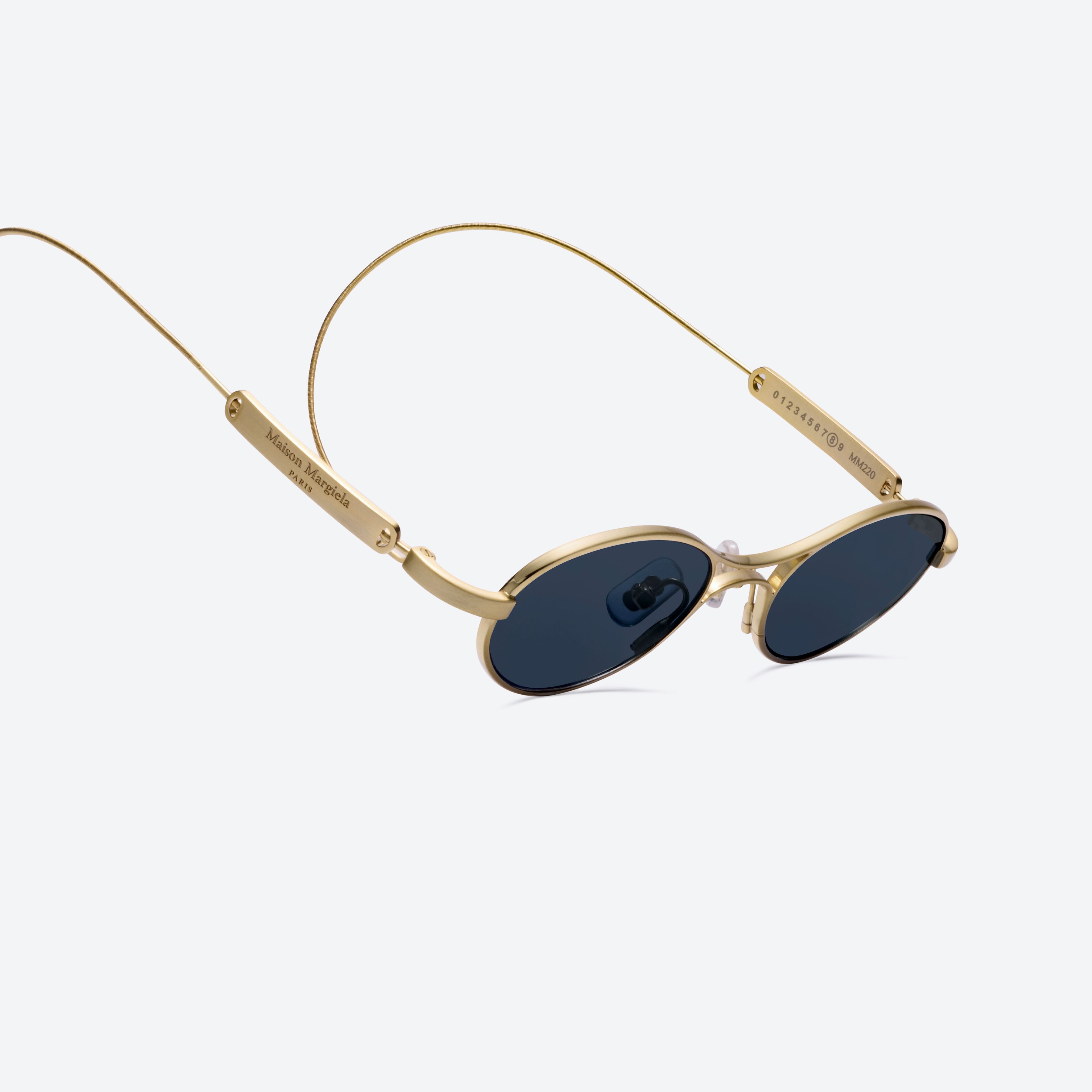 A detailed left view of Gentle Monster MM220 A030(N) Gold Metal framed Oval glasses.