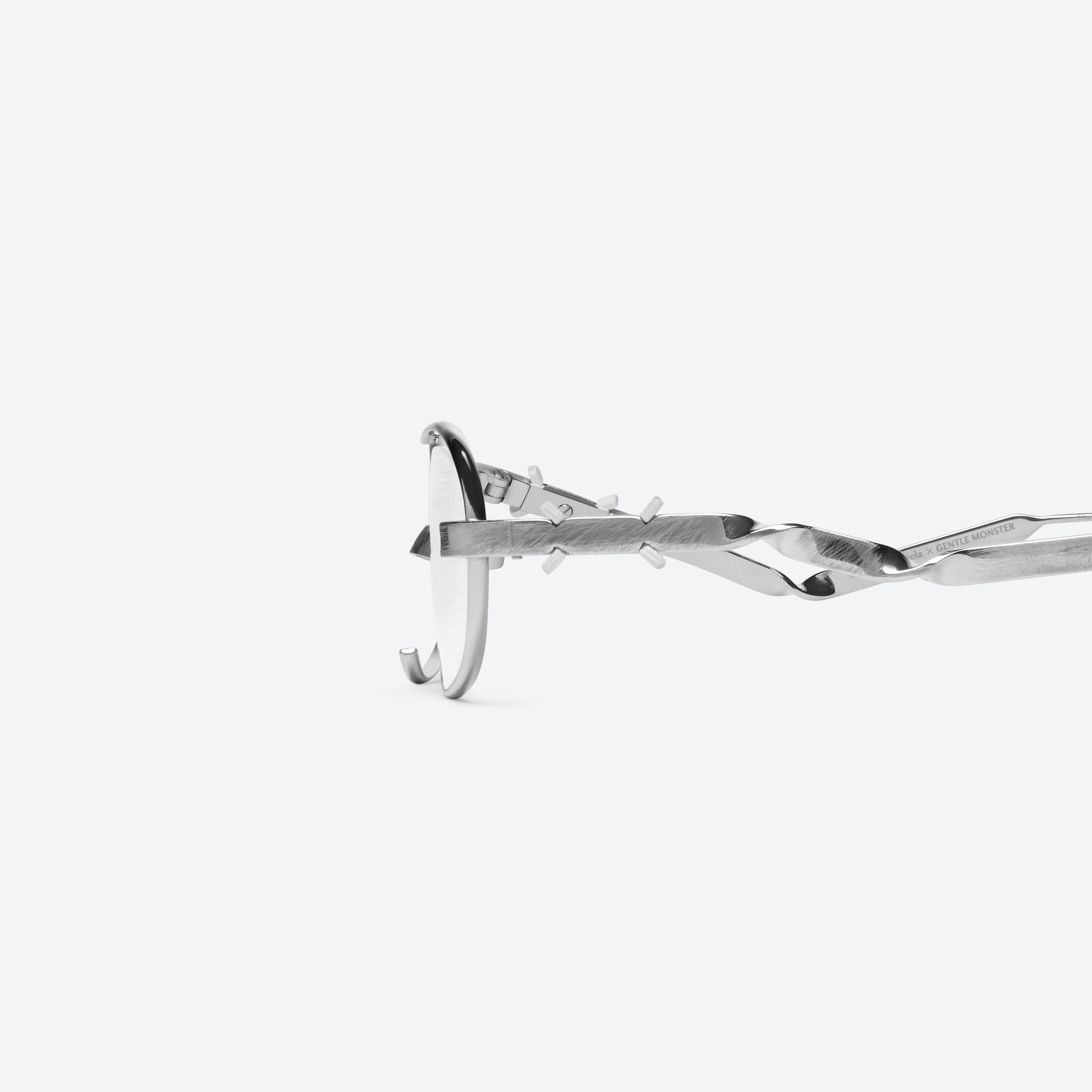 A detailed left view of Gentle Monster Maison Margiela - MM301 02 Silver Metal framed Oval glasses.
