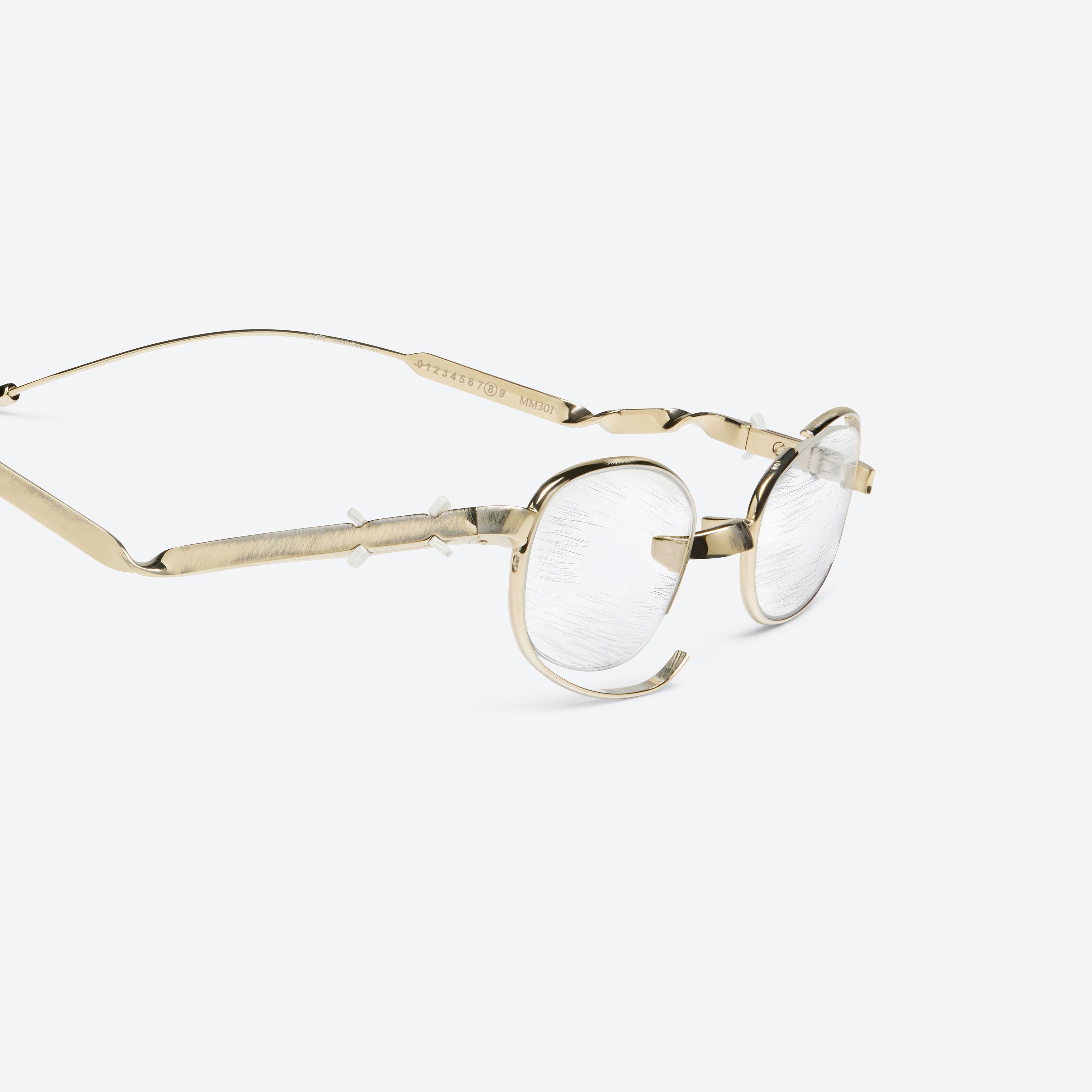 45-degree detailed view of Gentle Monster Maison Margiela - MM301 039 Gold Metal framed Oval glasses.