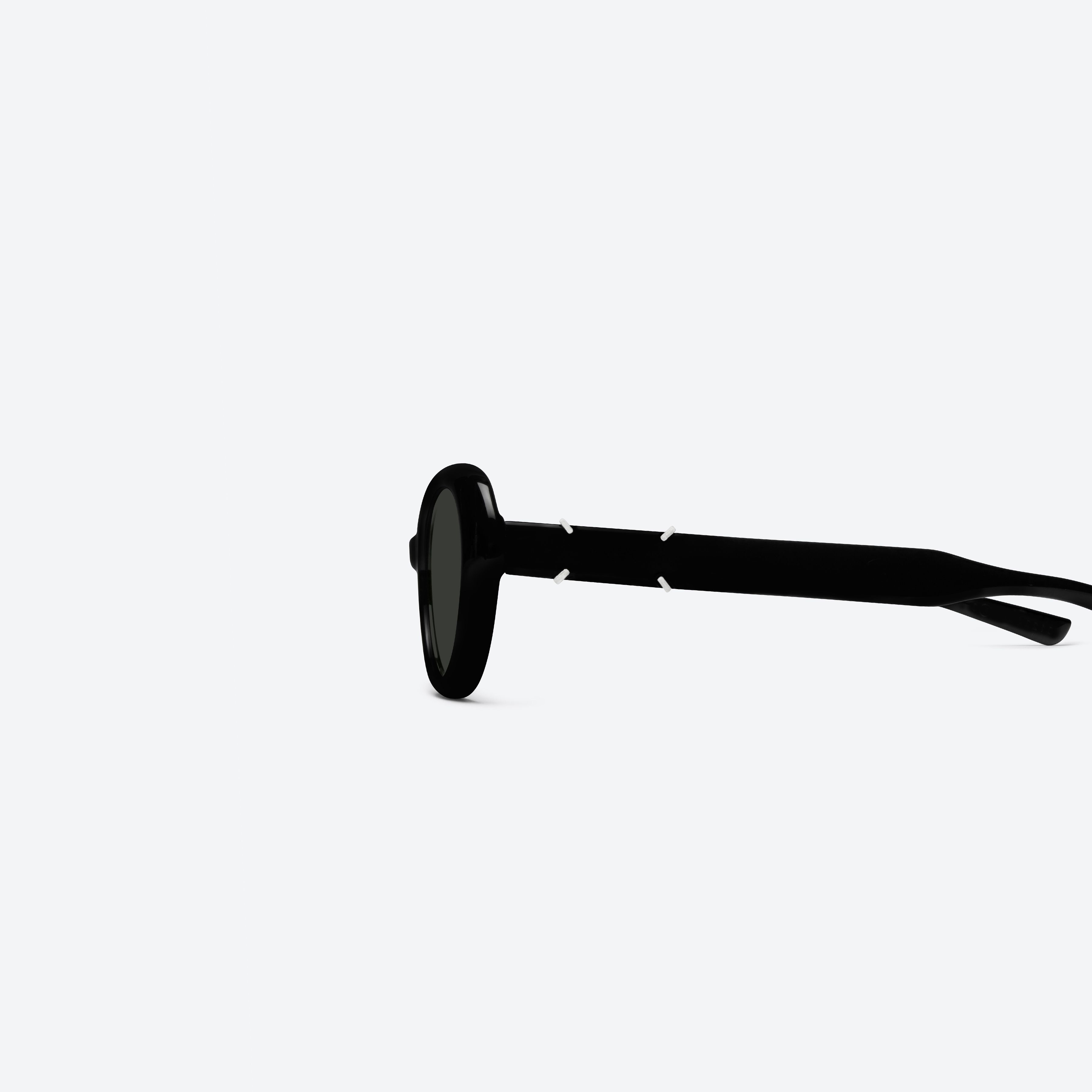A detailed left view of Gentle Monster Maison Margiela - MM317 01 Black Acetate framed Oval sunglasses.
