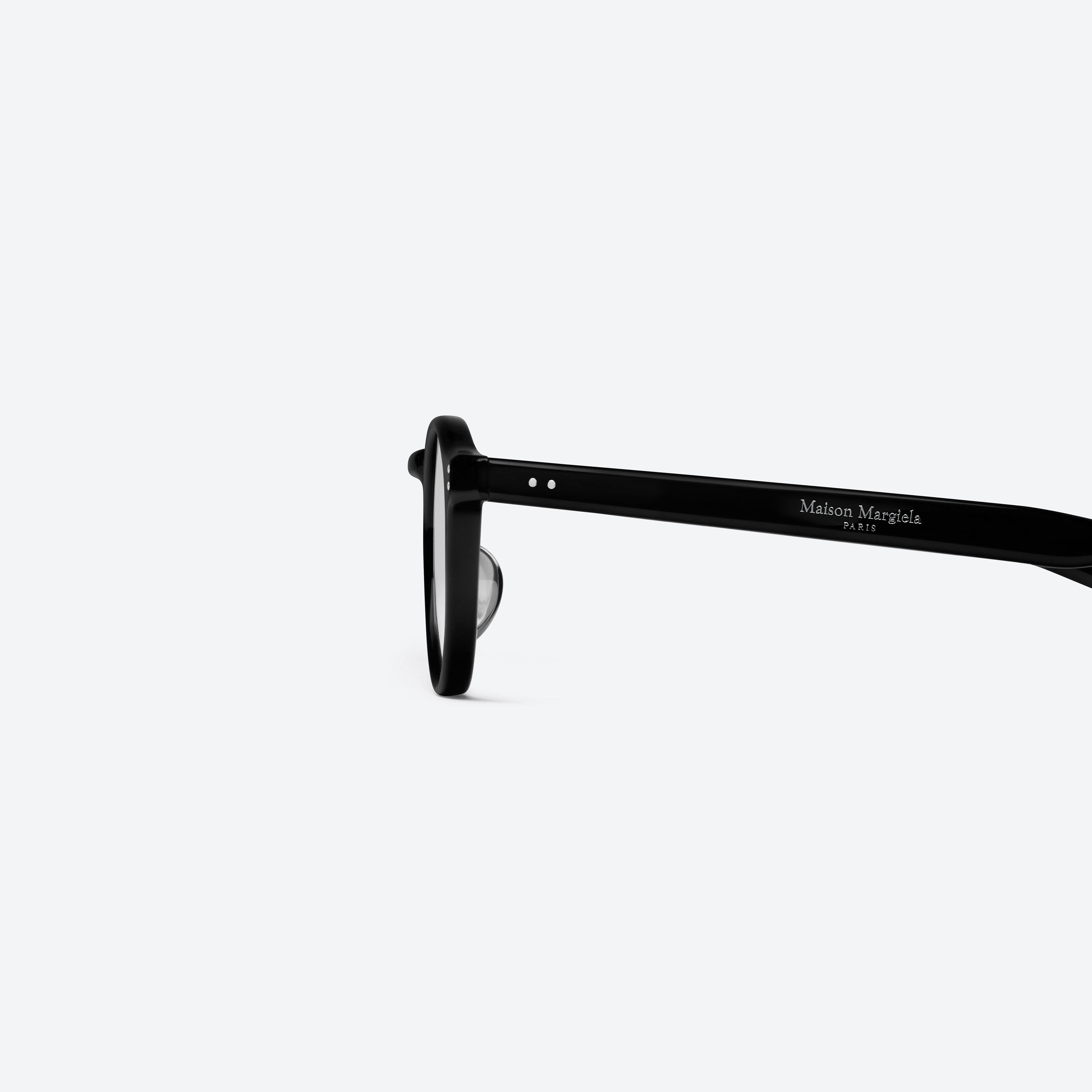 A detailed left view of Gentle Monster Maison Margiela - MM309 01 Black Acetate framed Round glasses.