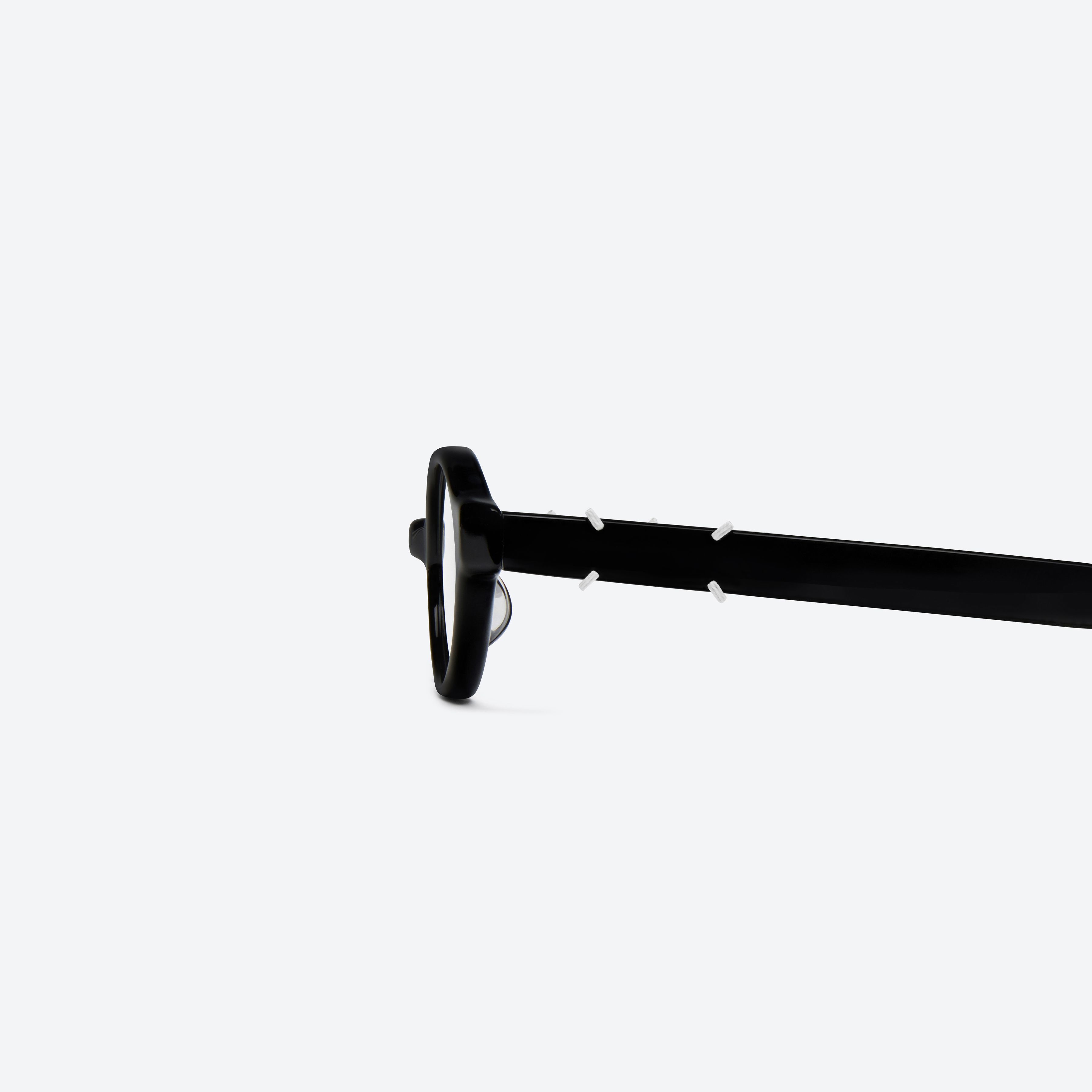 A detailed left view of Gentle Monster Maison Margiela - MM312 01 Black Acetate framed Oval glasses.